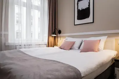 a bedroom with a large white bed with pink pillows at Imagine Apartments in Kraków