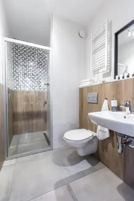 a bathroom with a shower and a toilet and a sink at Wawel Cracow Old City Apartments - Friendhouse Apartments in Kraków