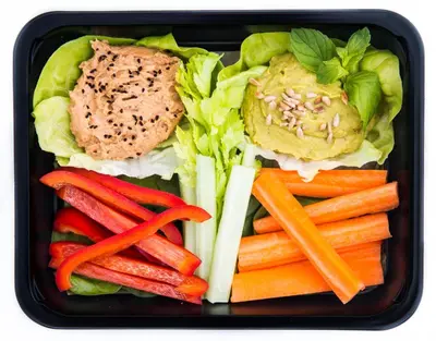 a black container filled with vegetables and a sandwich at Wawel Cracow Old City Apartments - Friendhouse Apartments in Kraków