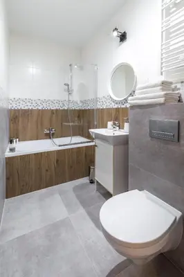 a bathroom with a toilet and a tub and a sink at Wawel Cracow Old City Apartments - Friendhouse Apartments in Kraków