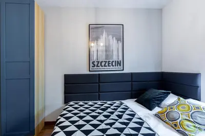 a bed with a blue headboard in a bedroom at Wawel Cracow Old City Apartments - Friendhouse Apartments in Kraków
