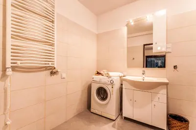 a bathroom with a washing machine and a sink at Willa Stróża in Myślenice