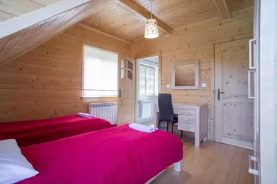 a kitchen with white cabinets and a white refrigerator at Mosorny Park Drewniane Komfortowe Domki Całoroczne in Zawoja