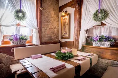 a dining room with two tables and two windows at Hotel - Karczma Klimtówka in Wolbrom