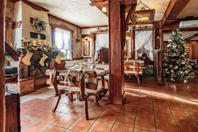 a dining room with a table and a christmas tree at Hotel - Karczma Klimtówka in Wolbrom