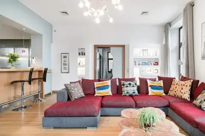 a living room with a red couch with pillows at Style4rent Apartament Kazimierz in Kraków
