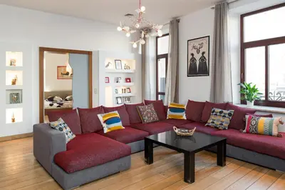 a living room with a red couch and a table at Style4rent Apartament Kazimierz in Kraków