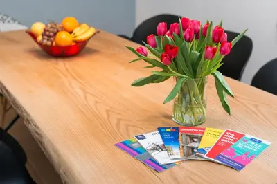 a vase of flowers on a table with a bowl of fruit at Style4rent Apartament Kazimierz in Kraków