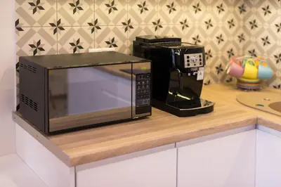 a microwave sitting on a counter next to a coffee maker at Cheerful Air Conditioned Apartment with mezzanine and Parking - Old Town in Kraków