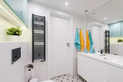 a bathroom with a sink and a toilet and a mirror at Cheerful Air Conditioned Apartment with mezzanine and Parking - Old Town in Kraków