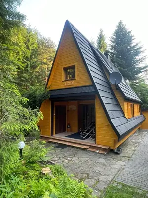 a small yellow house with a gambrel roof at Domek Krasnal in Juszczyn