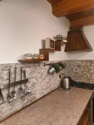 a kitchen with a counter with utensils on the wall at Domek Krasnal in Juszczyn