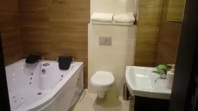 a bathroom with a tub and a toilet and a sink at Hotel Graal Targowisko in Targowisko