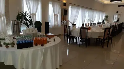 a dining room with white tables and chairs and a long table at Hotel Graal Targowisko in Targowisko