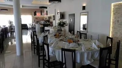 a dining room with a long white table and chairs at Hotel Graal Targowisko in Targowisko