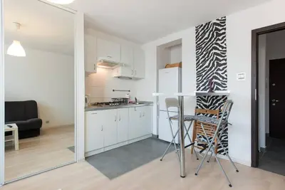 a kitchen with a table and chairs in a room at Studio Aleja Pokoju in Kraków