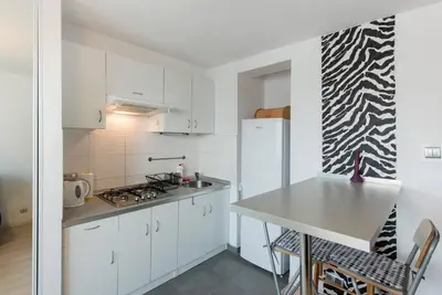 a kitchen with white cabinets and a counter top at Studio Aleja Pokoju in Kraków