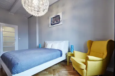 a bedroom with a bed and a yellow chair at PlayRoom II Apartment in Kraków