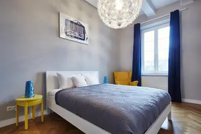 a bedroom with a bed and a chandelier at PlayRoom II Apartment in Kraków
