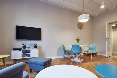 a living room with a table and chairs and a tv at PlayRoom II Apartment in Kraków