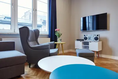 a living room with a couch and chairs and a tv at PlayRoom II Apartment in Kraków