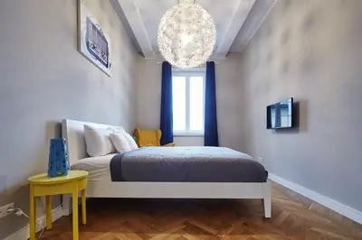 a bedroom with a bed and a chandelier at PlayRoom II Apartment in Kraków