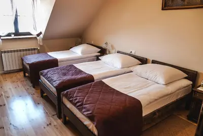 a room with three beds in a room at Hotel Pod Kogutkiem in Krzywaczka