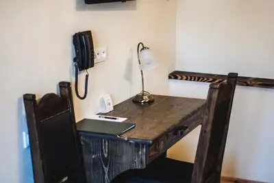 a wooden desk with a lamp and a phone on a wall at Hotel Pod Kogutkiem in Krzywaczka