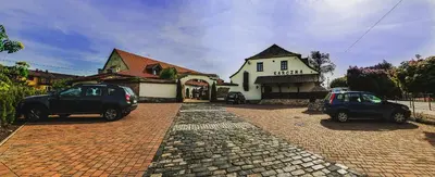 two cars parked on a brick road in front of a building at Hotel Pod Kogutkiem in Krzywaczka
