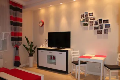 a living room with a television and a table and chairs at Carmen Apartment in Kraków