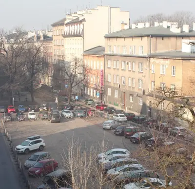 a parking lot with cars parked in front of buildings at Carmen Apartment in Kraków