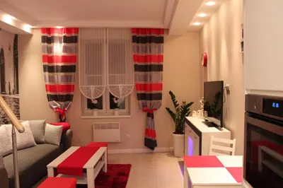 a living room with red and white curtains at Carmen Apartment in Kraków