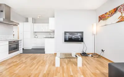 a white living room with a couch and a table at Apartment Zegadłowicza in Kraków