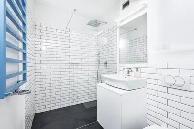 a white bathroom with a sink and a mirror at Apartment Zegadłowicza in Kraków