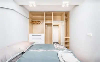 a bedroom with a bed and a closet at Apartment Zegadłowicza in Kraków