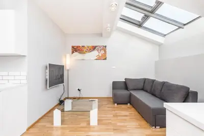 a living room with a couch and a table at Apartment Zegadłowicza in Kraków