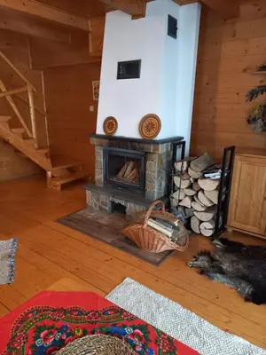 a living room with a fireplace in a log cabin at Domek drewniany simonka zawoja in Zawoja