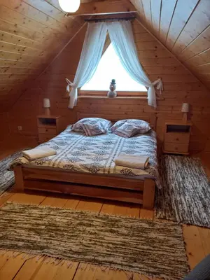 a bed in a log cabin with a window at Domek drewniany simonka zawoja in Zawoja