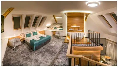 a hotel room with a bed and a table and chairs at Hotel Limanova in Limanowa