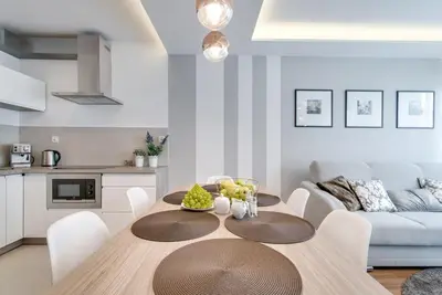 a kitchen and dining room with a table and a couch at Apartment Masarska in Kraków