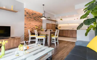 a living room and kitchen with a table and a couch at Apartment Masarska in Kraków