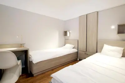 a room with two beds and a desk and a bed sidx sidx sidx at Apartment Masarska in Kraków