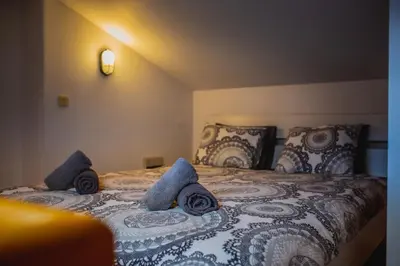 a bedroom with a bed with blue and white blankets and pillows at Top Apartments - Dunin Wąsowicza in Kraków