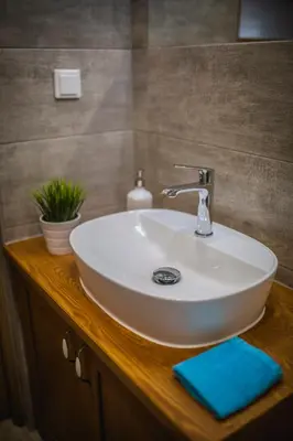 a white sink sitting on a wooden counter in a bathroom at Top Apartments - Dunin Wąsowicza in Kraków