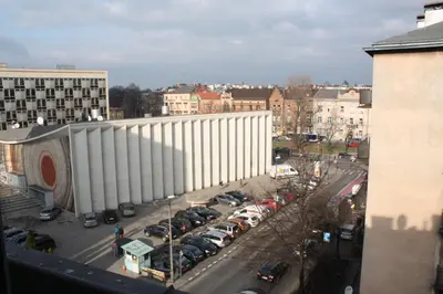 a large white building in a city with parked cars at Top Apartments - Dunin Wąsowicza in Kraków