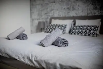 a bed with two rolled up towels on it at Top Apartments - Dunin Wąsowicza in Kraków