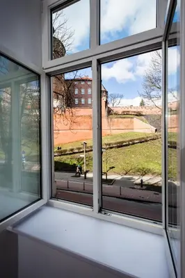 a window with a view of a field seen through it at Apartment Bernardynska in Kraków