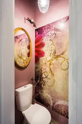 a bathroom with a toilet and a painting on the wall at Apartment Bernardynska in Kraków