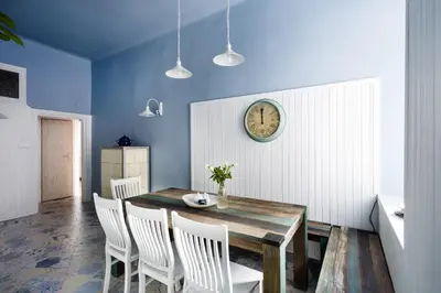 a dining room with a table and chairs and a clock at Apartment Bernardynska in Kraków