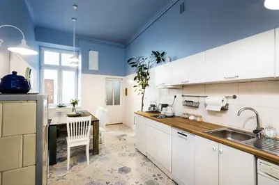 a kitchen with white cabinets and a blue ceiling at Apartment Bernardynska in Kraków